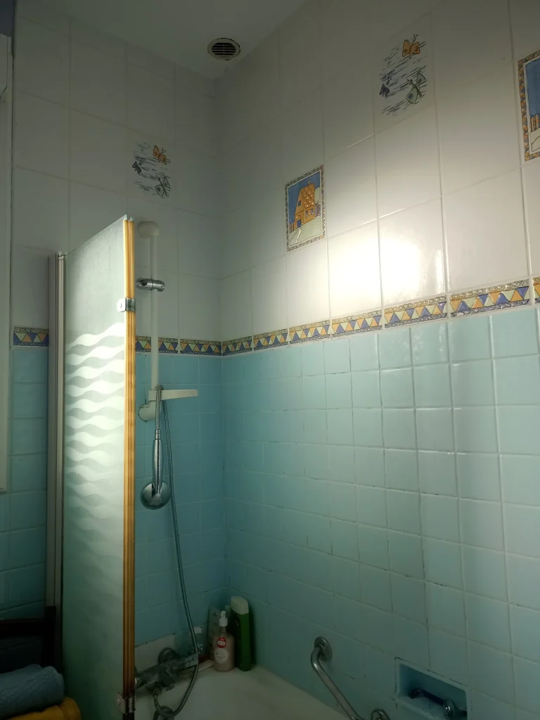 Espace douche avec faïence bleue – état existant avant rénovation partielle