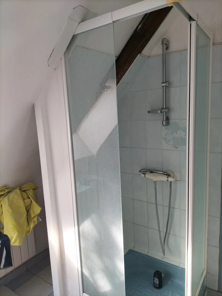 Douche d’angle existante sous pente avant rénovation