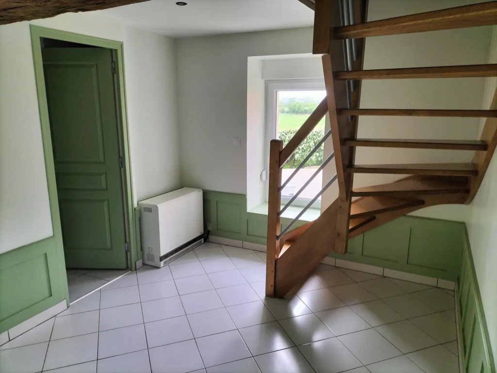 Couloir avec murs peints clairs et soubassement vert soutenu