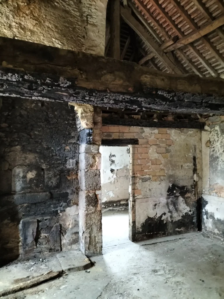 Enduit cloqué et suie sur mur intérieur d’une annexe sinistrée
