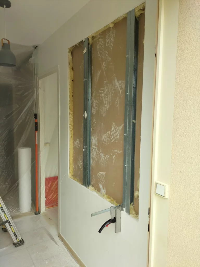 Pose de verrière intérieure – cloison ouverte, rails métalliques en cours d'installation