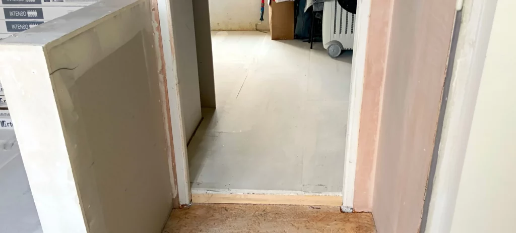Jonction entre deux pièces réalisée avec une chape sèche dans un passage de porte