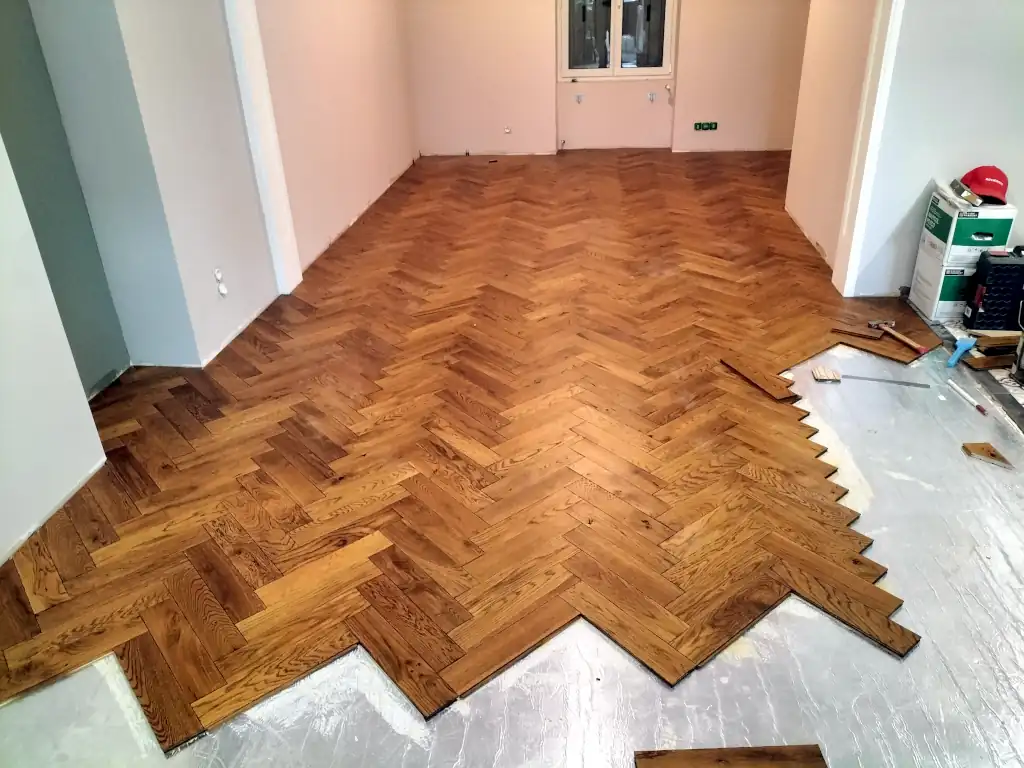 Pose d’un parquet à chevrons en bois massif dans une pièce de vie en rénovation